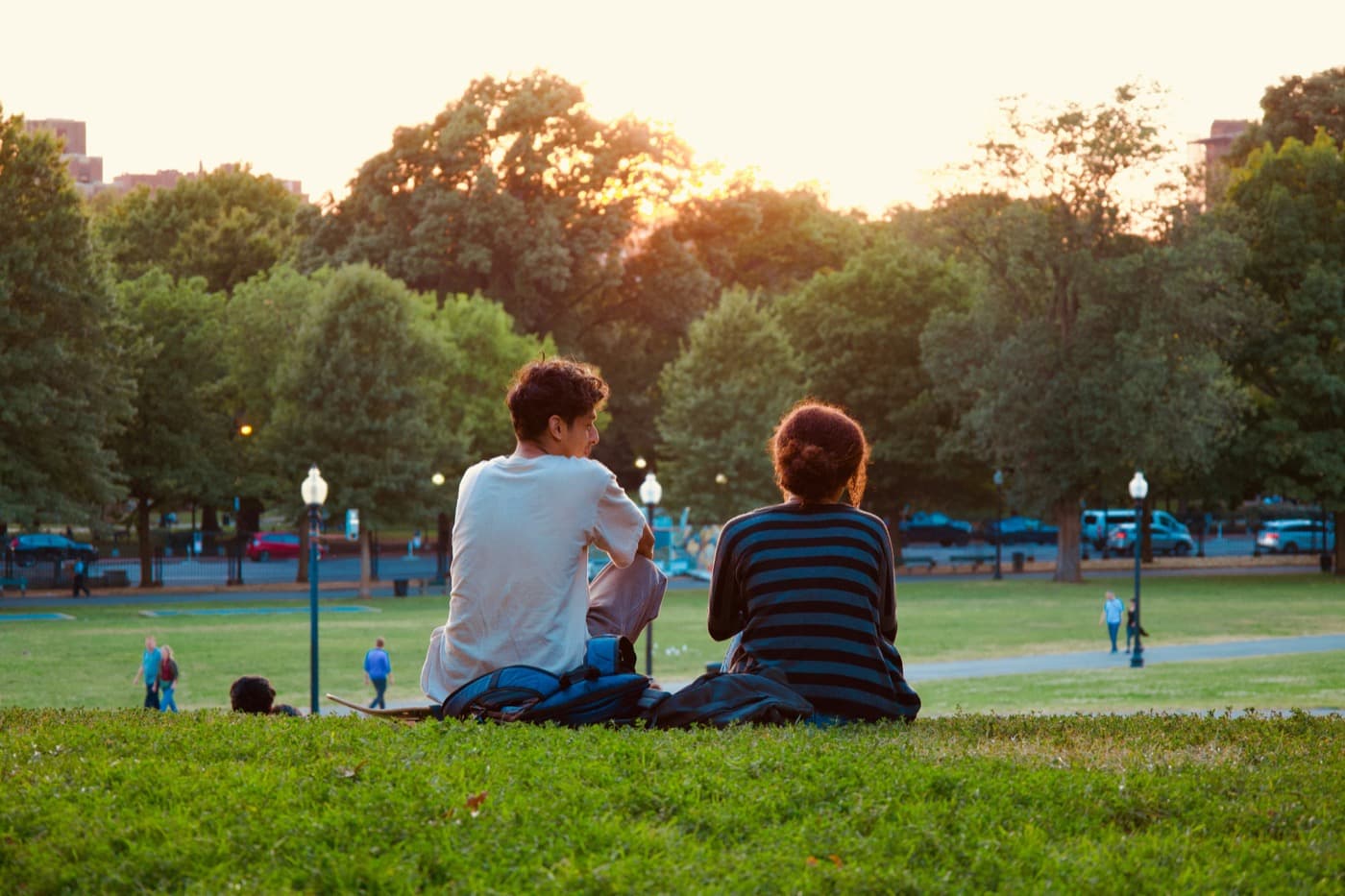 A couple sitting together in a park at sunset
